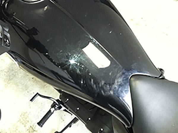 Black motorcycle tank before, dull and swirled